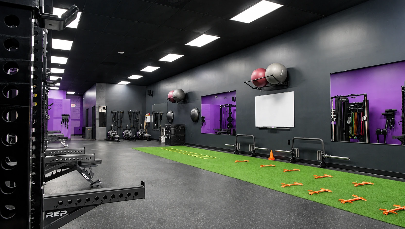 Functional training zone with turf strip, agility ladders, and wall-mounted accessories at Galaxy Fit Lab Naples